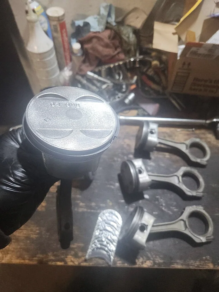 New piston inspected before engine assembly